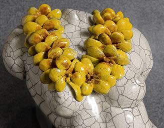 Close up of torso sculpture with big yellow lei
